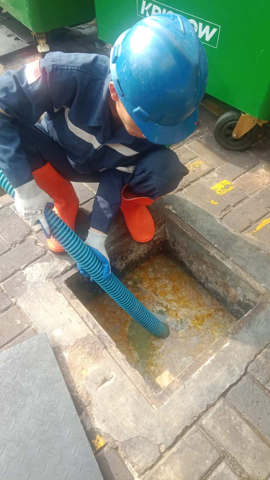 Teknisi BMP Sedot WC sedang bekerja secara profesional dan berseragam resmi
